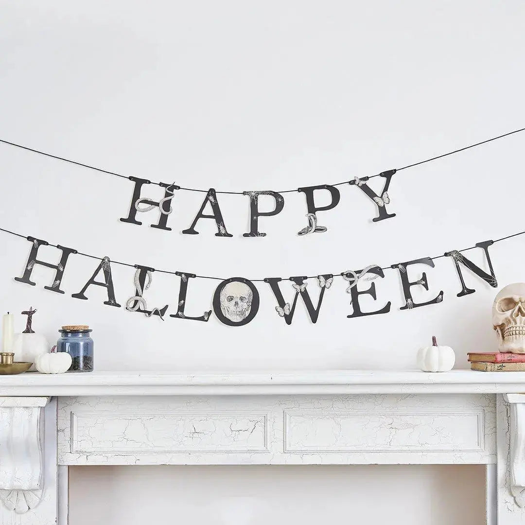 Black Happy Halloween bunting displayed above a mantel for a Creepy Chic party