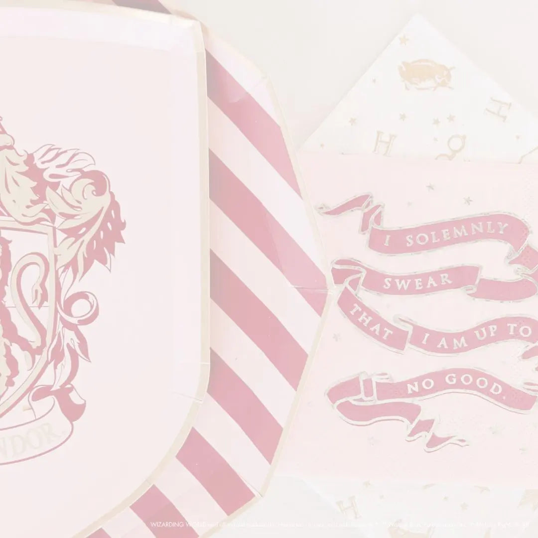 Faded pink and red Harry Potter Gryffindor plates and napkins arranged for a party table
