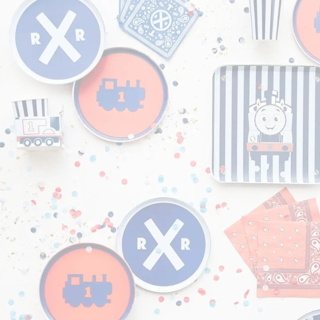 Faded overhead view of Thomas & Friends plates, cups and napkins in red, blue and railway designs