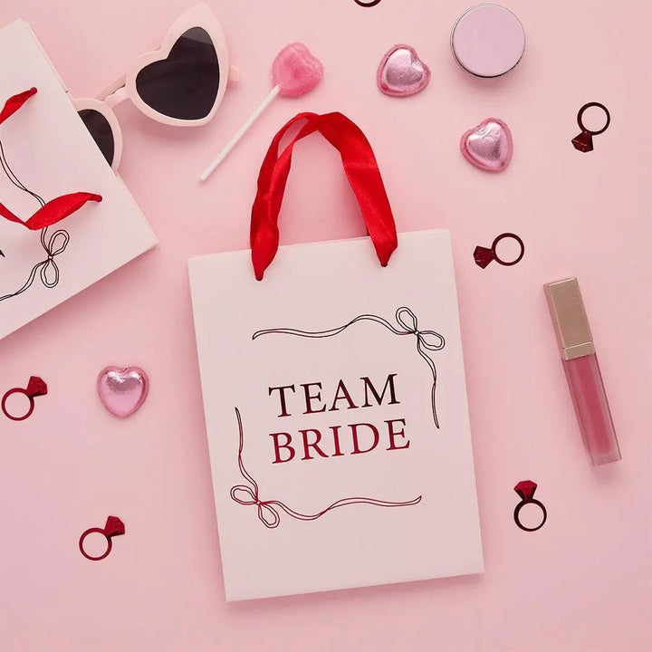 Team Bride Party Bags - Pink & Red She’s Tying The Knot Hen Do Gifts - Coquette Hen Party Gift Bags with Red Satin Handles - Pack of 5 - Jolie Fete UK